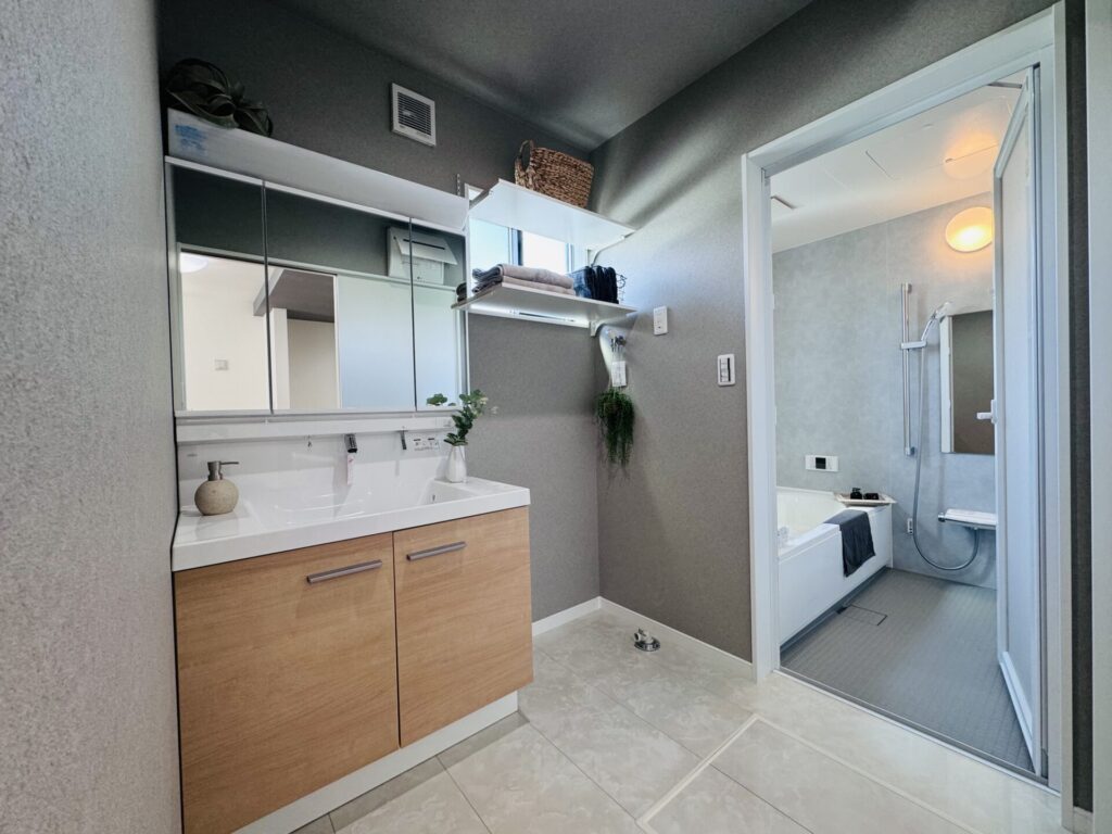 ナチュラルな木の素材の洗面台とグレーのクロスのバランスが素敵な洗面所