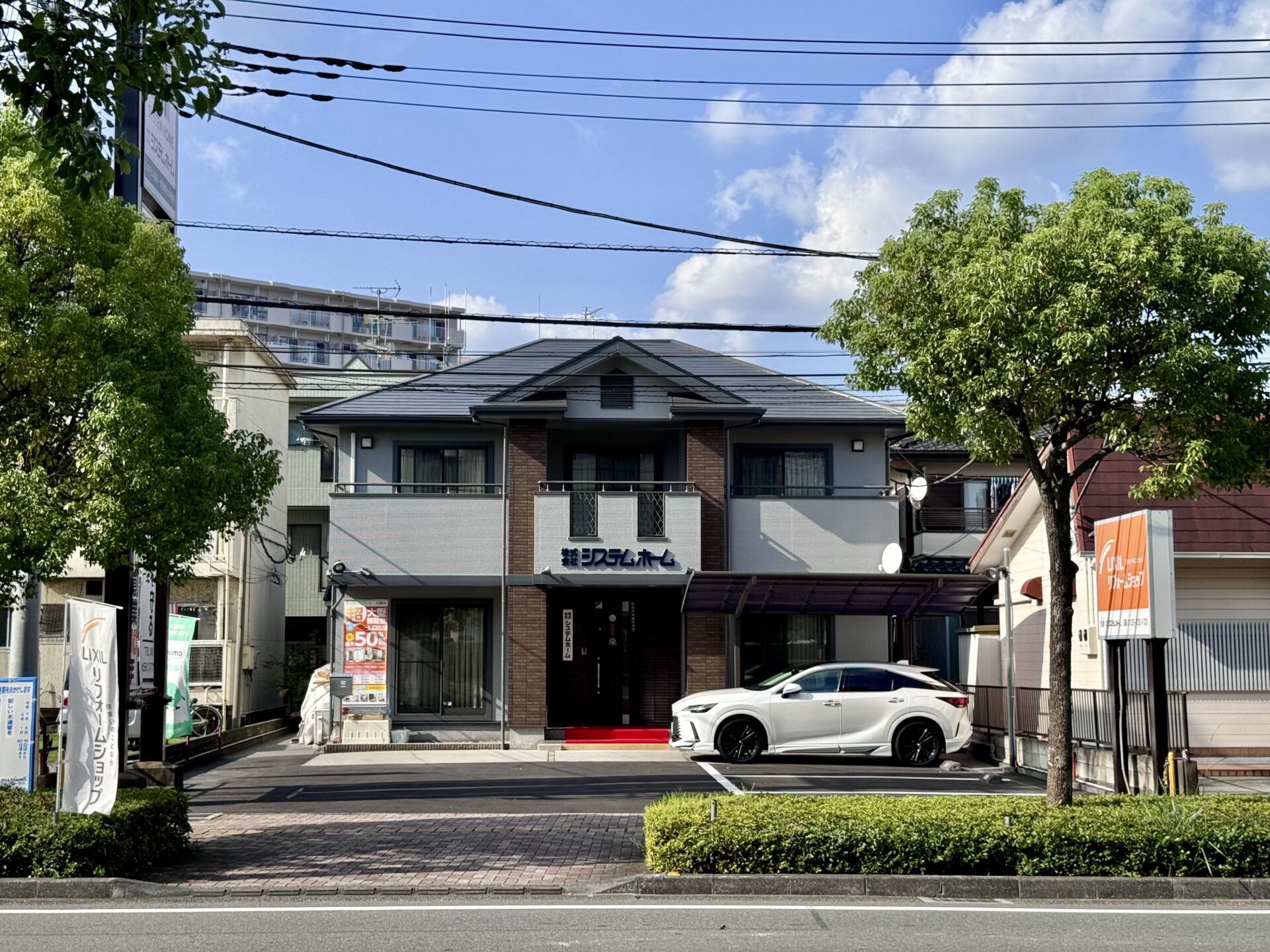 新越谷・南越谷駅から徒歩5分にある株式会社システムホームの店舗外観と駐車場